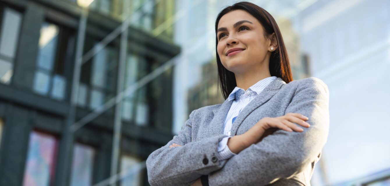low-angle-businesswoman-posing-with-arms-crossed-city